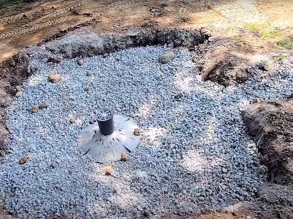 Drainage systems dry well filled with crushed stone around a round emitter
